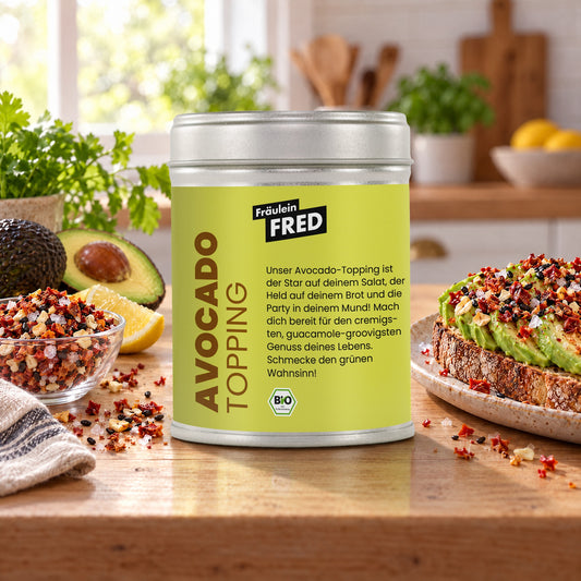 Avocado Topping in der Dose von Fräulein Fred auf dem Küchentisch, daneben Avocado-Toast