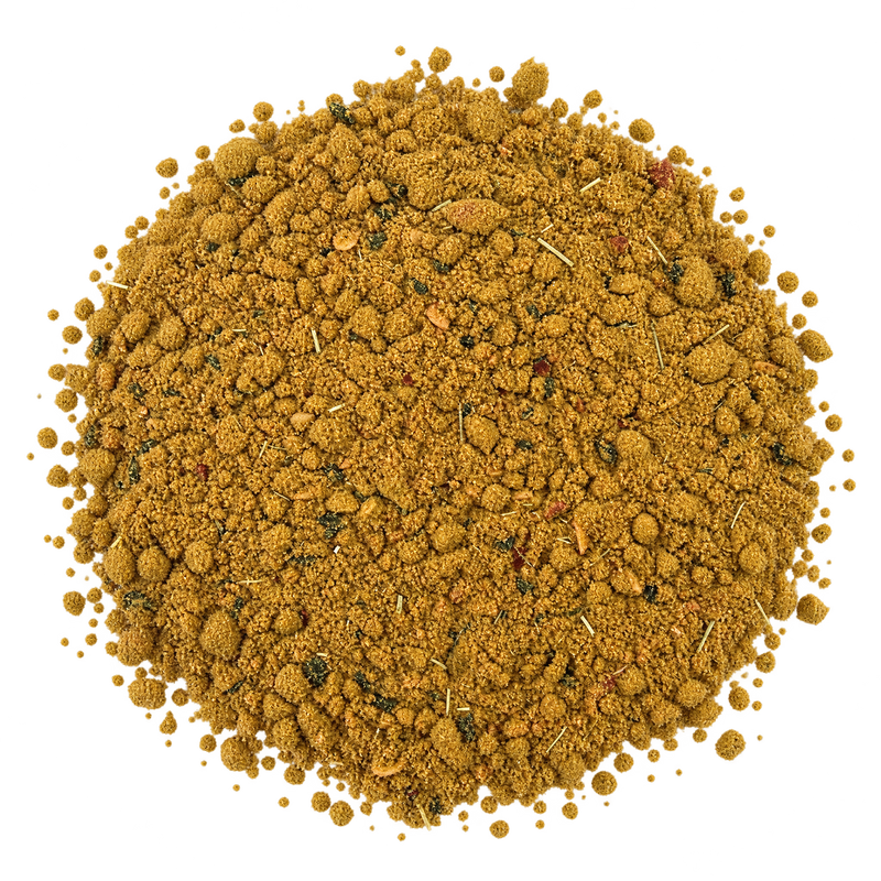 Madras Curry Detailansicht – fein gemahlenes ockerfarbenes Currypulver mit Curryblättern und Chili